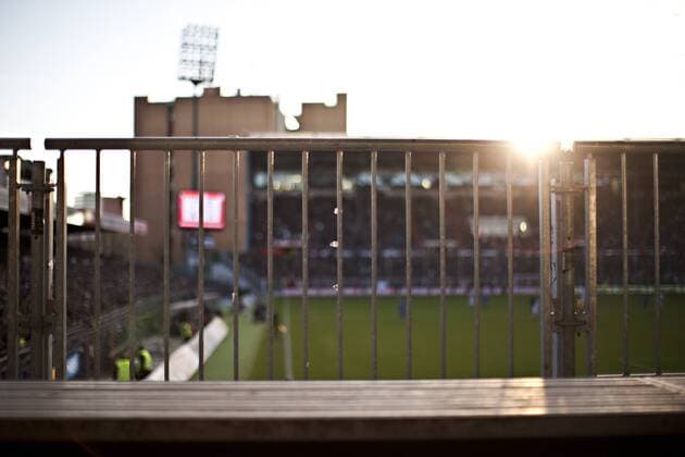 Fußball, Stadiongeschichte FC St. Pauli Blick auf ein Geländer. Im Hintergrund die Anzeigentafel, die Südtribüne und das Spielfeld des Millerntor Stadion, Heimspielstätte FC St. Pauli - - Saison 2011 2012