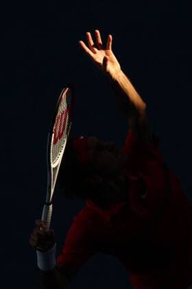 typical: hand and racquet (of Roger Federer) through the shadowed court at RLA of 2012 Tennis Australian Open in Melbourne, 24 01 2012 -