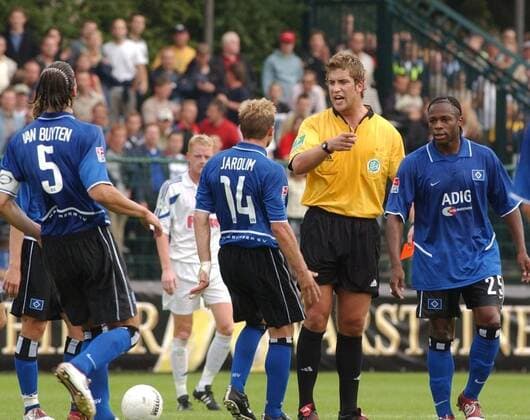 Robert Hoyzer (2.v.re.) mit HSV-Spielern 08 04 hör Mann Fußball Profifußball Bundesliga Pokal Pokalspiel DFB Schiedsrichter Unparteiischer kurzhaarig dunkelhaarig sportlich Trikot leger quer ganz stehend draußen Spielfeld Rasen Partie Spiel Spieler Gestik gestikulierend Logo Daniel Van Buyten, David Jarolim, Emile Mpenza (v.l.) Pokalspiel SC Paderborn 07 gegen Hamburger SV (HSV) am 21.08.2004 in Paderborn (Ergebnis 4:2)