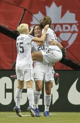 USA s Abby Wambach celebrates with teammates Alex Morgan (R) and Megan Rapinoe (L) after scoring the second goal of the game against Canada during the first half of match 15 of CONCACAF women s Olympic qualifying finals at BC Place in Vancouver, British Columbia, January 29, 2012. USA beat Canada 4-0.  VAP2012012925