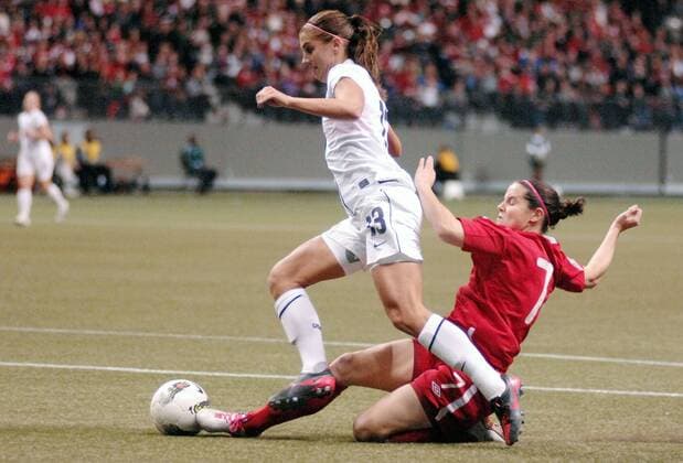 Alex Morgan (L) of US and Rhian Wilkinson of Canada fight for the ball during their final at 2012 CONCACAF Women s Olympic Qualifying Soccer Tournament at BC Place in Vancouver, Canada, Jan. 29, 2012. US defeated Canada 4-0 and captured the CONCACAF trophy. Both teams qualified to go to 2012 Summer Olympic Games in London. (Xinhua Sergei Bachlakov) CANADA-VANCOUVER-CONCACAF-WOMEN S OLYMPIC QUALIFYING-FINAL 