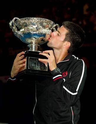 Novak Djokovic of Serbia kisses the trophy during the awarding cerermony for the men s singles final at 2012 Australian Open tennis tournament in Melbourne, Australia, on Jan. 29, 2012. (Xinhua Bai Xue) (hy) AUSTRALIA-MELBOURNE-TENNIS-MEN S-FINAL 