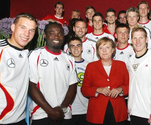 Fussball Herren Nationalmannschaft WM Weltmeisterschaft 2006 : Bundeskanzlerin Angela MERKEL (m) im Kreis der Mannschaft. Die Bundeskanzlerin der Bundesrepublik Deutschland, Angela MERKEL, besuchte am heutigen Dienstag abend die deutsche Fussball Nationalmannschaft in ihrem Quartier im Schlosshotel Grunewald in Berlin. (Photo by Tobias Kuberski - Pool Baumann)