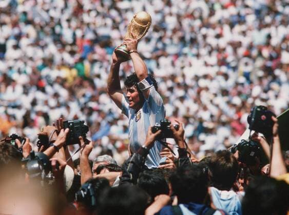 Fussball Weltmeisterschaft WM 1986 Finale Endspiel Deutschland vs. Argentinien der weltbeste Fussballspieler, Armando Diego Maradona, hält triumphierend den schweren Goldpokal in Händen. Seine Kameraden tragen ihn im Freudentaumel minutenlang über den Platz. Ein würdiger Weltmeister.