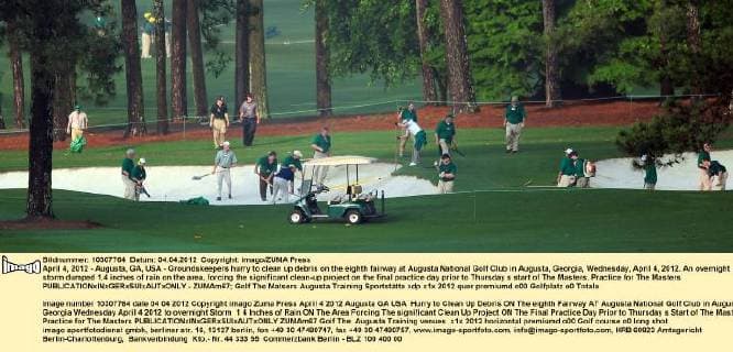 April 4, 2012 - Augusta, GA, USA - Groundskeepers hurry to clean up debris on the eighth fairway at Augusta National Golf Club in Augusta, Georgia, Wednesday, April 4, 2012. An overnight storm dumped 1.4 inches of rain on the area, forcing the significant clean-up project on the final practice day prior to Thursday s start of The Masters. Practice for The Masters - ZUMAm67