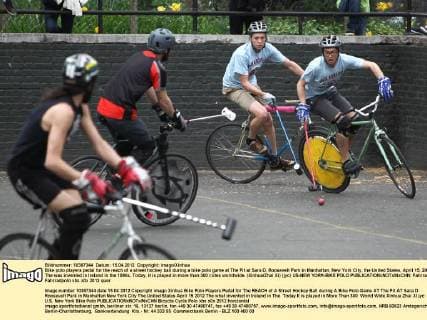 Bike polo players pedal for the reach of a street hockey ball during a bike polo game at The Pit at Sara D. Roosevelt Park in Manhattan, New York City, the United States, April 15, 2012. The was invented in Ireland in the 1890s. Today, it is played in more than 300 ciites worldwide. (Xinhua Zhai Xi) (jyc) US-NEW YORK-BIKE POLO 