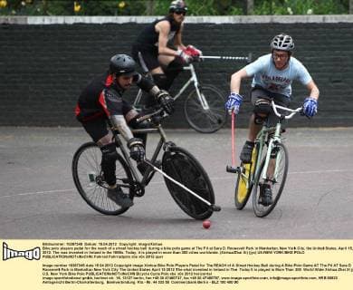 Bike polo players pedal for the reach of a street hockey ball during a bike polo game at The Pit at Sara D. Roosevelt Park in Manhattan, New York City, the United States, April 15, 2012. The was invented in Ireland in the 1890s. Today, it is played in more than 300 ciites worldwide. (Xinhua Zhai Xi) (jyc) US-NEW YORK-BIKE POLO 