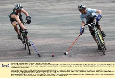 Bike polo players pedal for the reach of a street hockey ball during a bike polo game at The Pit at Sara D. Roosevelt Park in Manhattan, New York City, the United States, April 15, 2012. The was invented in Ireland in the 1890s. Today, it is played in more than 300 ciites worldwide. (Xinhua Zhai Xi) (jyc) US-NEW YORK-BIKE POLO 