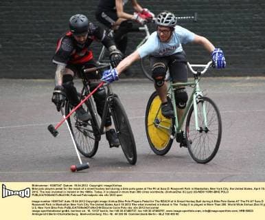 Bike polo players pedal for the reach of a street hockey ball during a bike polo game at The Pit at Sara D. Roosevelt Park in Manhattan, New York City, the United States, April 15, 2012. The was invented in Ireland in the 1890s. Today, it is played in more than 300 ciites worldwide. (Xinhua Zhai Xi) (jyc) US-NEW YORK-BIKE POLO 