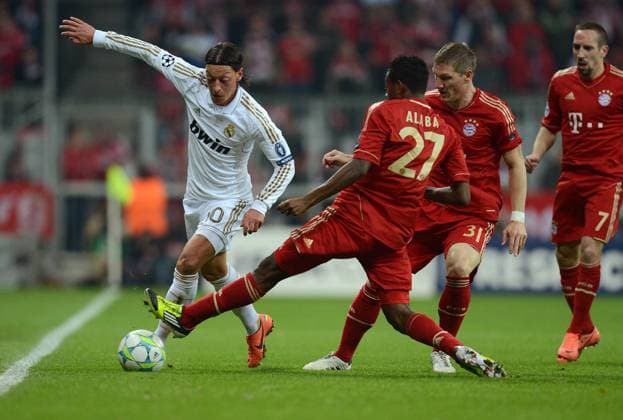 FUSSBALL CHAMPIONS LEAGUE HALBFINAL HINSPIEL 2011 2012 FC Bayern München - Real Madrid 17.04.2012 Mesut Özil (li, Real Madrid) gegen David Alaba, Bastian Schweinsteiger und Franck Ribery (v.l., alle FC Bayern München) 