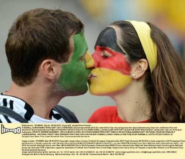FUSSBALL EUROPAMEISTERSCHAFT 2012 VORRUNDE Deutschland 09.06.2012 Ein männlicher Fan mit portugiesischer Gesichtsbemalung küsst ein weiblichen Fan mit deutscher Gesichtsbemalung  FUL2090612005c