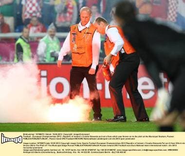 Football - European Championships 2012 - Republic of Ireland v Croatia Stewards put out a flare which was thrown on to the pitch at the Municipal Stadium, Poznan 