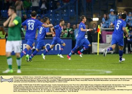 Croatia celebrate scoring their third goal while Robbie Keane of Republic of Ireland looks on dejected in the foreground..Euro 2012 Group Stage (Group C) match, Republic Of Ireland v Croatia at the Municipal Stadium, Poznan on the 10th June 2012. EDITORIAL USE ONLY. No use with unauthorised audio, video, data, fixture lists, club league logos or live services. Online in-match use limited to 120 images, no video emulation. No use in betting, games or single club league player publications.