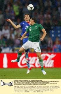 Ivan Perisic of Croatia and Keith Andrews of Republic of Ireland leap for the ball..Euro 2012 Group Stage (Group C) match, Republic Of Ireland v Croatia at the Municipal Stadium, Poznan on the 10th June 2012. EDITORIAL USE ONLY. No use with unauthorised audio, video, data, fixture lists, club league logos or live services. Online in-match use limited to 120 images, no video emulation. No use in betting, games or single club league player publications.