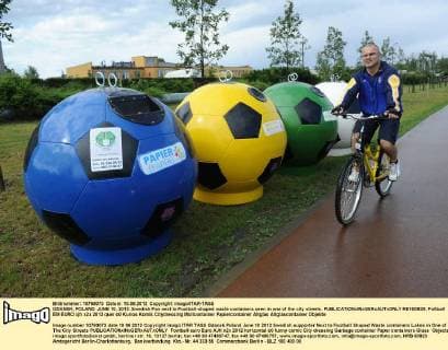 GDANSK, POLAND. JUNE 10, 2012. Swedish Fan next to Football-shaped waste containers seen in one of the city streets.  RE100B39