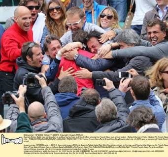 Spanish Rafael Nadal (red shirt center) is mobbed by his team and family after winning his French Open men s final match - Roland Garros in Paris - Nadals 7th French Open title -  PAR20120611718