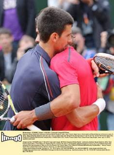 Spanish Rafael Nadal (R) embraces Serbian Novak Djokovic after their French Open men s final match at Roland Garros in Paris on June 11, 2012. Nadal defeated Djokovic 6-4, 6-3, 2-6, 7-5 in a match that was delayed one day because of rain to win his record 7th French Open title.  PAR20120611720