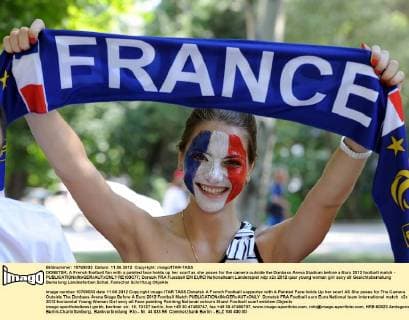 DONETSK, A French football fan with a painted face holds up her scarf as she poses for the camera outside the Donbass Arena Stadium before a Euro 2012 football match -  RE100C77
