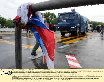 A Russian national flag on a railing with a riot police vehicle in the background in central Warsaw.  RE100F01