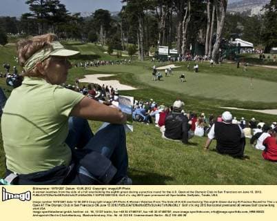 A woman watches from the side of a hill overlooking the eighth green during a practice round for the U.S. Open at the Olympic Club in San Francisco on June 13, 2012.  SXP2012061325