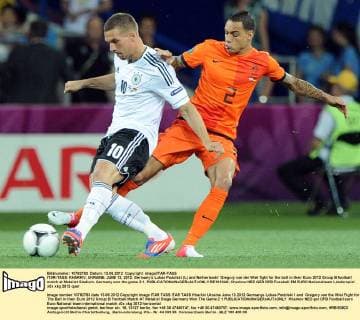 ITAR-TASS: KHARKIV, UKRAINE. JUNE 13, 2012. Germanyâ€™s Lukas Podolski (L) and Netherlandsâ€™ Gregory van der Wiel fight for the ball in their Euro 2012 Group B football match at Metalist Stadium. Germany won the game 2:1.  RE1010A0