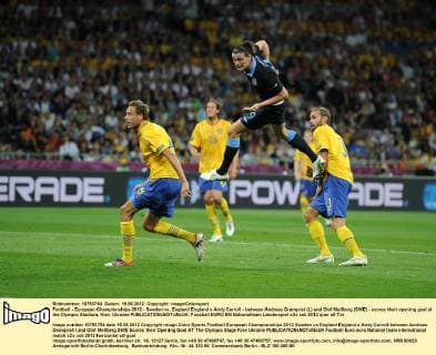 Football - European Championships 2012 - Sweden vs. England England s Andy Carroll - between Andreas Granqvist (L) and Olof Mellberg (SWE) - scores their opening goal at the Olympic Stadium, Kiev, Ukraine 