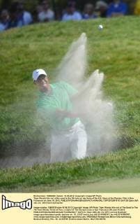Tiger Woods hits out of the sand to the 7th hole on day three of the U.S. Open at the Olympic Club in San Francisco on June 16, 2012.  SFP2012061615