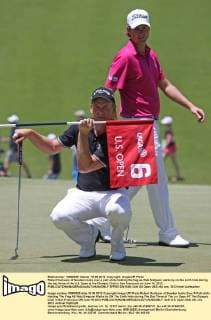 Robert Karlsson of Sweden looks over a putt while holding the flag as Web Simpson walks by on the sixth hole during the day three of the U.S. Open at the Olympic Club in San Francisco on June 16, 2012.  SFP2012061648