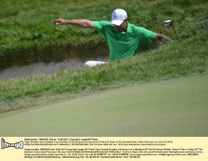 Tiger Woods slips climbing in to a bunker at the 7th green on day three of the U.S. Open at the Olympic Club in San Francisco on June 16, 2012.  SFP2012061608