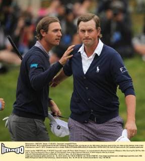Webb Simpson (R) is congratulated by Nicolas Colsaerts of Belgium after scoring par on the 18th hole in the final round of the U.S. Open at the Olympic Club in San Francisco on June 17, 2012. Simpson won by a stroke.  SFP2012061729