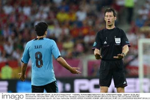 FUSSBALL EUROPAMEISTERSCHAFT 2012 VORRUNDE Kroatien - Spanien 18.06.2012 Schiedsrichter Wolfgang Stark (GER, re) ermahnt Xavi Hernandez (Spanien) 