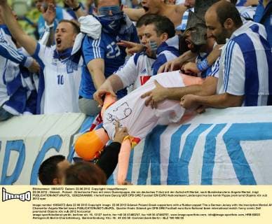 22.06.2012 - Gdansk , Poland . Griechische Fans mit einer Gummipuppe, die ein deutsches Trikot mit der Aufschrift Merkel, nach Bundeskanzlerin Angela Merkel, trägt  120622WAN006