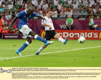 Football - European Championships 2012 - Germany vs. Italy Mario Balotelli of Italy strikes past Philipp Lahm of Germany to score his second goal at the National Stadium, Warsaw 
