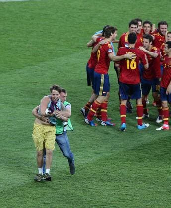 Fans (L) run into the pitch after the final match between Italy and Spain at the Euro 2012 football championships in Kiev, Ukraine, July 1, 2012. Spain won 4-0 to claim the title. (Xinhua Meng Yongmin) (jyc) UKRAINE-KIEV-EURO 2012 FOOTBALL CHAMPIONSHIPS-FINAL 