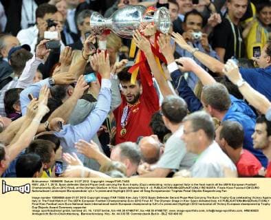 KIEV. JULY 1, 2012. Spain defender Gerard Pique (red) carrying the Euro trophy (Cup) celebrating victory against Italy in the final match of the UEFA European Football Championship (Euro 2012 final), at the Olympic Stadium in Kiev. Spain defeated Italy 4 - 0.  RE1026FA