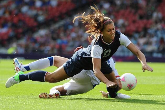 July 25, 2012 - Glasgow, GBR - Alex Morgan (13) gets tangled up with France s Sonia Bompastor during 2012 Olympic s competition Wednesday, July 25, 2012 at legendary Hampden Park in Glasgow, Scotland. Though the Games do not start until Friday, soccer starts early and Cal grad Morgan shined in her Olympic debut with two goals in the American s 4-2 victory. Women s soccer: USA v. France - ZUMAm67