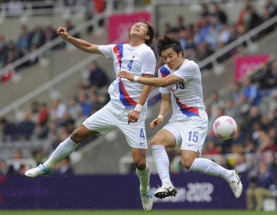 South Korea s Kim Young-Gwon (L) and Park Jong-Woo end up going for the ball at the same time..London Olympic 2012 first round Group B men s match between Mexico v South Korea at the St. James Park, Newcastle upon Tyne on the 26th July 2012. Pic Richard Lee SPORTIMAGE... EDITORIAL USE ONLY. No use with unauthorised audio, video, data, fixture lists, club league logos or live services. Online in-match use limited to 120 images, no video emulation. No use in betting, games or single club league player publications.