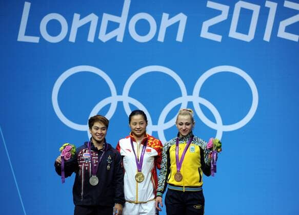 Gold Medalist Li Xueying of China (C), silver medalist Pimsiri Sirikaew of Thailand (L) and Yuliya Kalina of Ukraine pose for pictures during the victory ceremony of women s weightlifting 58kg competition, at London 2012 Olympic Games in London - 