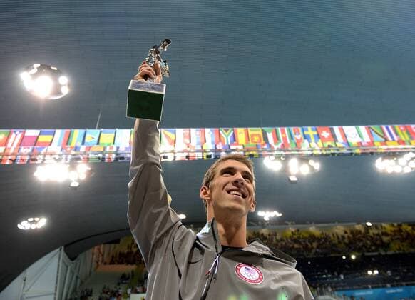 LONDON, Aug. 4, 2012 -- USA swimmer Michael Phelps poses with a trophy from FINA acknowledgning his achievement in the Olympic history after competing in men s 4x100 medley relay contest, at London 2012 Olympic Games in London, Britain, on August 4, 2012. (Xinhua Li Gang) (nxl) (OLY2012)BRITAIN-LONDON-SWIMMING-MICHAEL PHELPS-AWARD 