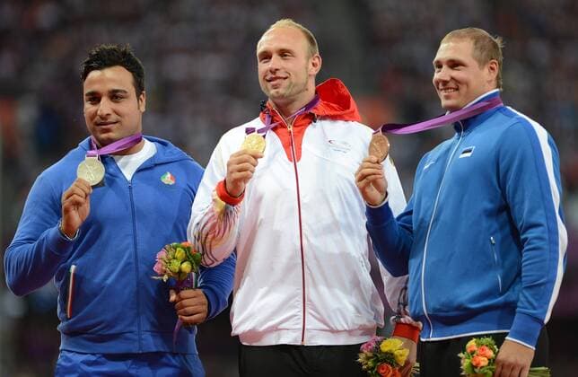 LONDON, Aug. 7, 2012 - Gold medalist Robert Harting (C) of Germany, silver medalist Ehsan Hadadi (L) of Iran, and bronze medalist Gerd Kanter of Estonia pose at awarding ceremony of men s Discus Throw contest, at London 2012 Olympic Games in London, Britain, on August 7, 2012. (OLY2012)BRITAIN-LONDON-ATHLETICS-MEN S DISCUS THROW-AWARDING 