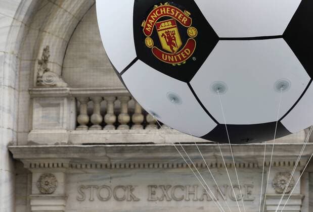 A soccer ball with the Manchester United Logo floats outside of the New York Stock Exchange on the morning that Manchester United Lists its Initial Public Offering at the NYSE on Wall Street In New York City on August 10, 2012. Manchester United will begin trading today on the NYSE under the ticker symbol MANU.  NYP20120810115