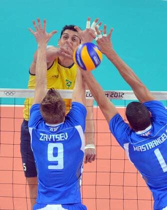 (120810) -- LONDON, Aug. 10, 2012 (Xinhua) -- Sidnei dos Santos Junior of Brazil (top) smashes the ball during the men s volleyball semifinal match between Brazil and Italy at London 2012 Olympic Games, London, Britain, Aug. 10, 2012. Brazil won the match 3-0. (Xinhua Fan Jun) (OLY2012)BRITAIN-LONDON-VOLLEYBALL-BRAZIL VS ITALY 