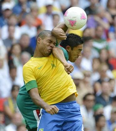 Defender Juan Jesus of Brazil (L) and forward Marco Fabian of Mexico go for the ball during the first half of the Gold Medal Football Match at the London 2012 Summer Olympics on August 11, 2012 at Wembley Stadium, London.  OLY20120811406