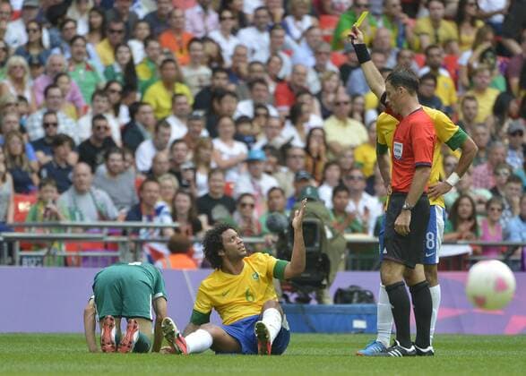 Defender Marcelo of Brazil (C) reacts after he is shown the yellow card during the first half of the Gold Medal Football Match at the London 2012 Summer Olympics on August 11, 2012 at Wembley Stadium, London.  OLY20120811408