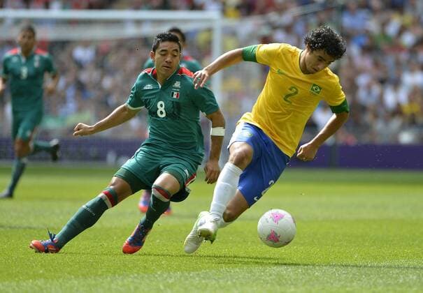 Forward Marco Fabian of Mexico and defender Rafael of Brazil go for the ball during the first half of the Gold Medal Football Match at the London 2012 Summer Olympics on August 11, 2012 at Wembley Stadium, London.  OLY20120811409