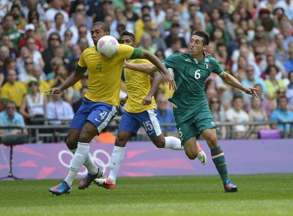 Defender Juan Jesus of Brazil (L) and midfielder Hector Herrera of Mexico go for the ball during the first half of the Gold Medal Football Match at the London 2012 Summer Olympics on August 11, 2012 at Wembley Stadium, London.  OLY20120811410