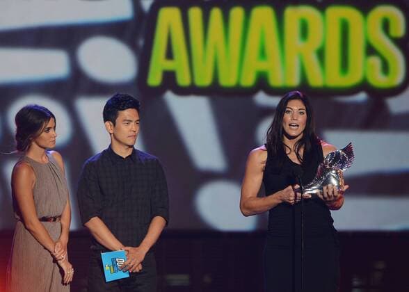 The U.S. women s soccer team goalie Hope Solo accepts her trophy from actors Nikki Reed (L) and John Cho after being selected the Athlete winner, beating out Cristiano Ronaldo, LeBron James, Tim Tebow and Serena Williams, during the Do Something Awards at Barker Hangar in Santa Monica, California on August 19, 2012.  LAP2012081923