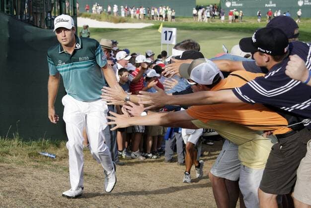 Nick Watney slaps hands with fans while he walks up to the 18th tee box in the final round of The Barclays 2012 FedExCup Playoffs at The Black Course at Bethpage State Park in Farmingdale, New York on August 26, 2012. Watney wins with a score of 10 under par.  NYP20120826129
