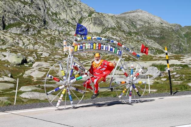 27.08.2012 Radsport. Bild zeigt Tourteufel Didi Senft bei seinem zwischenhalt auf dem Gotthardpass (Bild) mit seinem Spezialrad (Trinkflaschen diverser Radrennfahrer) auf dem Weg zur Eurobike nach Friedrichshafen GER Aktion Radsport Tourteufel 