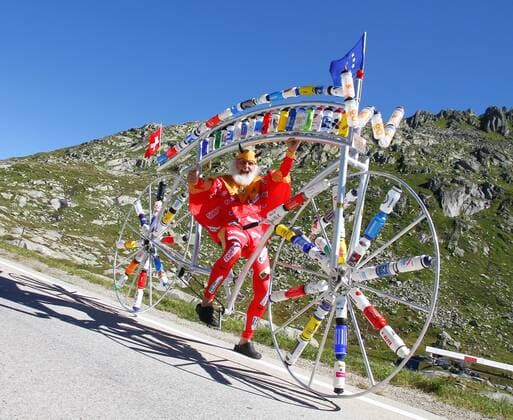 27.08.2012 Radsport. Bild zeigt Tourteufel Didi Dieter Senft bei seinem zwischenhalt auf dem Gotthardpass (Bild) mit seinem Spezialrad (Trinkflaschen diverser Radrennfahrer) auf dem Weg zur Eurobike nach Friedrichshafen GER Aktion Radsport Tourteufel 